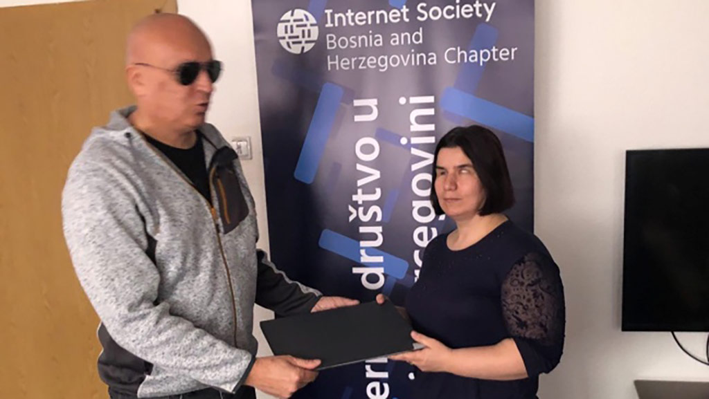 Predavač Hamdo Kentra uručuje laptop Sedini Dragunić
