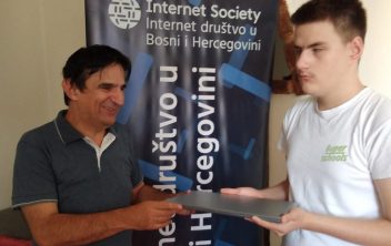 Figure 1. Lecturer Željko Bajić hands the laptop to candidate Tarik Hadžirović
